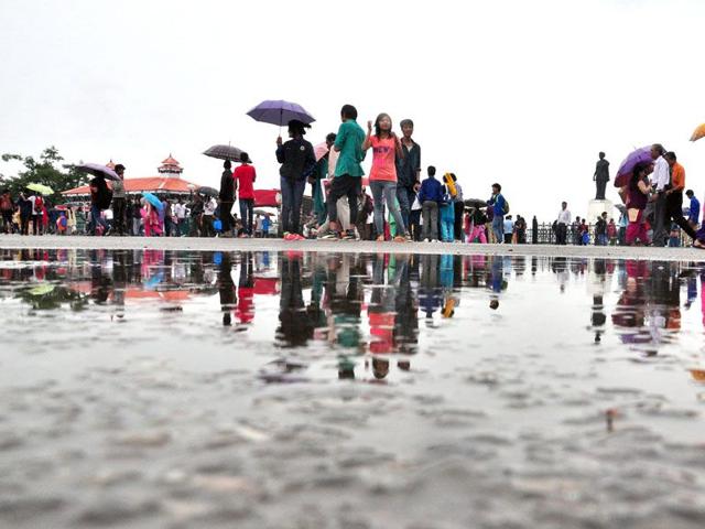 People enjoying themselves during rain at Ridge in Shimla on Wednesday. Santosh Rawat/HT