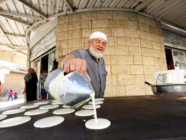 A man makes traditional sweets in a market in the town of Ramtha, Jordan. (Reuters Photo)