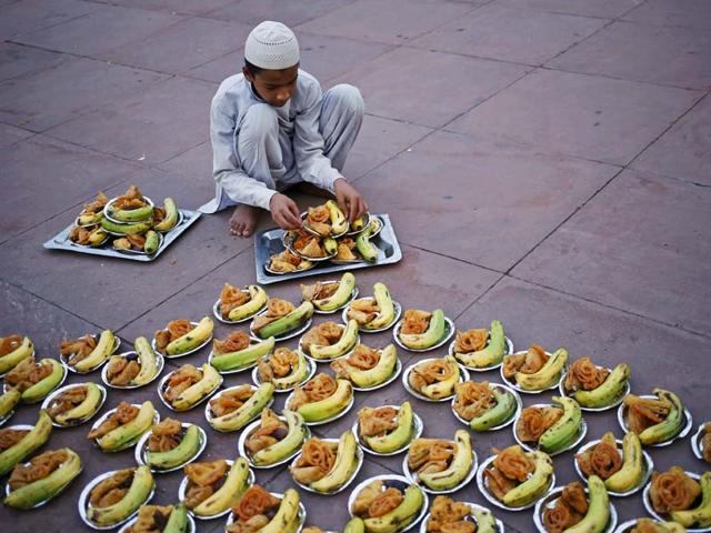 A Muslim boy prepares to distribute the Iftar (breaking of fast) meal at the Jama Masjid in the old quarters of Delhi. (REUTERS photo)
