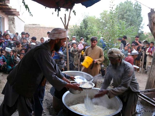 Afghan men distributing food in Ghazni. ( AFP PHOTO )
