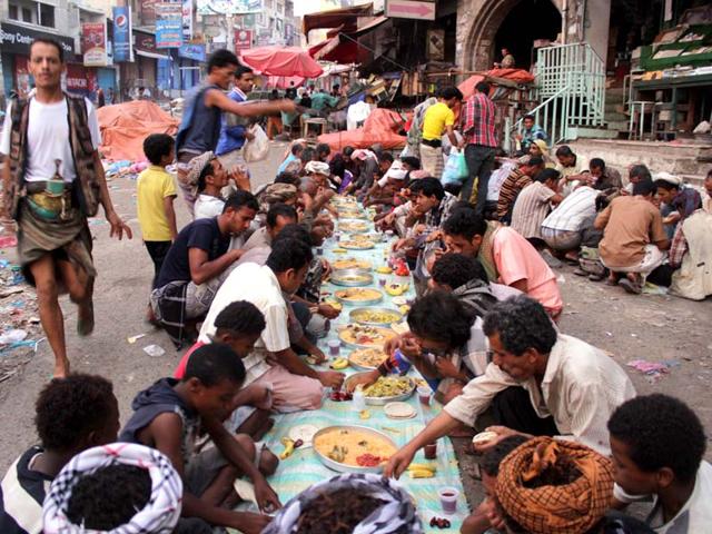 Yemenis break their fast as they gather in the street to eat in the southern Yemeni city of Taez..( AFP PHOTO )
