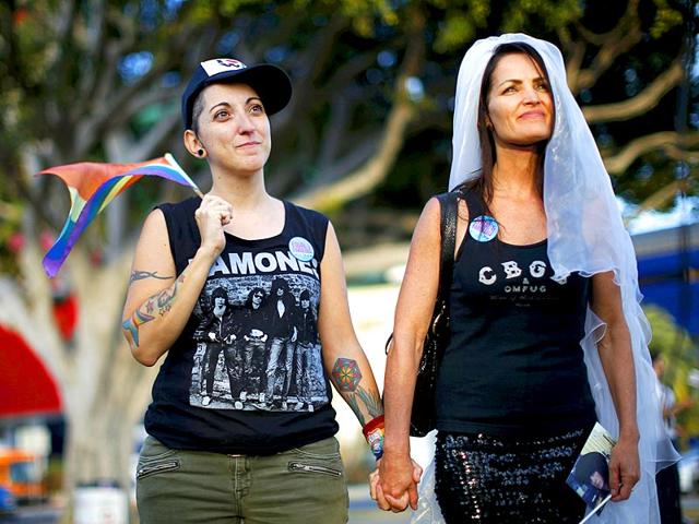 Natalie Novoa, 38, (L) walks with her wife Eddie Daniels at a celebration rally after getting married in West Hollywood. (Reuters)