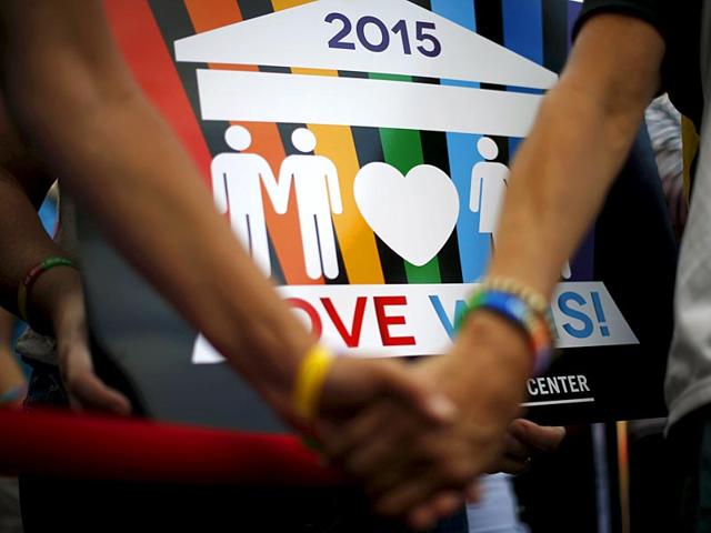 A couple hold hands at a celebration rally in West Hollywood, California. (Reuters)