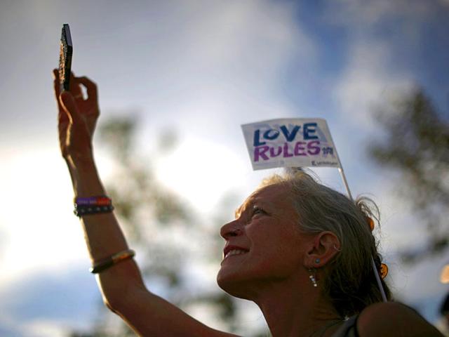 A woman takes a photo at a celebration rally in West Hollywood, California. (Reuters)