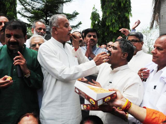 BJP state president Nand Kumar Singh Chauhan shares sweets with party men to celebrate party's win in Garoth by-poll, in Bhopal on Tuesday. (Mujeeb Faruqui/HT)
