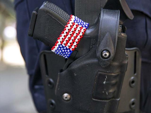 A bracelet in the design of the US flag is seen on the gun of a police officer in Manhattan, New York ahead of the Fourth of July holiday. (Reuters Photo)