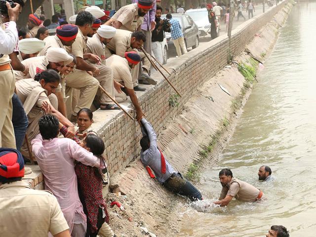 The-teachers-who-jumped-into-the-canal-after-police-lathicharge-being-rescued-by-cops-HT-Photo