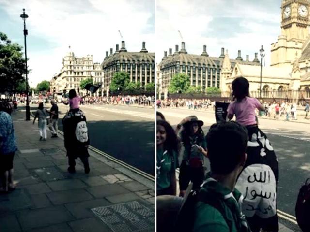 The-man-was-photographed-walking-past-a-group-of-Scouts-outside-the-Houses-of-Parliament-as-he-wore-a-large-Islamic-State-in-Iraq-and-Syria-ISIS-flag-on-his-back-He-was-carrying-a-small-child-on-his-shoulders-who-was-waving-a-smaller-flag-The-incident-sparked-outrage-on-social-media-with-people-questioning-why-there-were-no-legal-consequences-Source-Youtube-