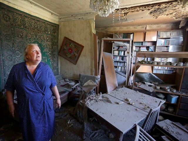 A woman assesses the damages to her house as a result of shelling between Ukrainian forces and pro-Russian separatists in the eastern Ukrainian city of Donetsk on Sunday. (AFP Photo) A woman assesses the damages to her house as a result of shelling between Ukrainian forces and pro-Russian separatists in the eastern Ukrainian city of Donetsk on Sunday. (AFP Photo)