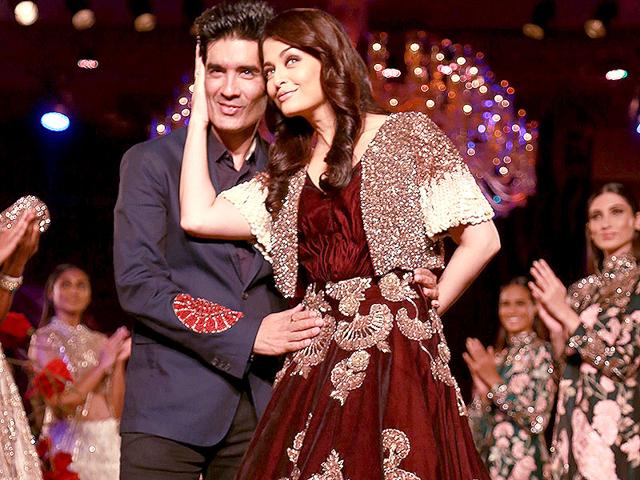 Aishwarya and Manish Malhotra strike a pose as the former Miss World walked the ramp in one of the designer's creation. (AP photo) 