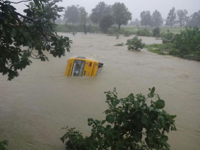 A school bus in Chor Pandra village of Betul was swept away on Tuesday as a river stream was in spate. All the children were rescued. (HT)
