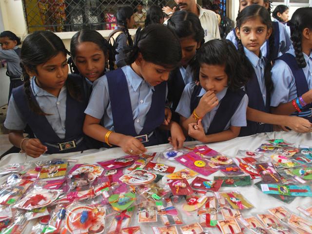 Students of the Gujarati School look at the rakhis made by their fellow classmates during an exhibition organised on school campus in Indore. (Shankar Mourya/HT)