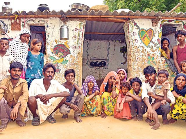 Family-members-of-Raju-Lohar-outside-their-dilapidated-hut-along-with-grieving-family-members-and-relatives-in-Vatika-village-on-Monday-Prabhakar-Sharma-HT-Photo Family-members-of-Raju-Lohar-outside-their-dilapidated-hut-along-with-grieving-family-members-and-relatives-in-Vatika-village-on-Monday-Prabhakar-Sharma-HT-Photo