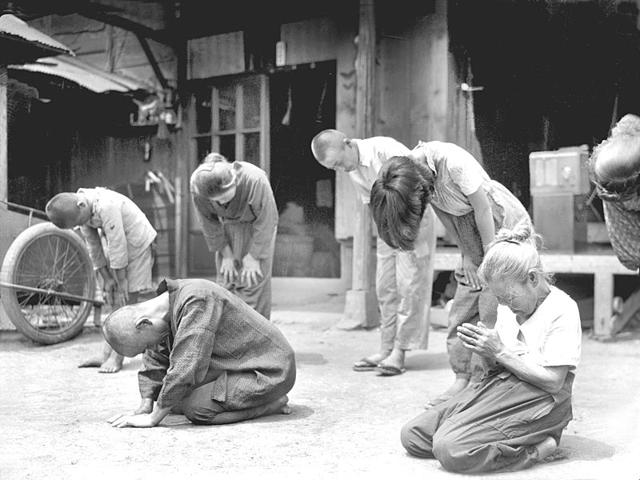 In this Aug 15, 1945 photo, Japanese people lower their head toward the Imperial Palace in Tokyo, as Emperor Hirohito announced on radio that Japan was defeated in the World War II. (Kyodo New via AP) In this Aug 15, 1945 photo, Japanese people lower their head toward the Imperial Palace in Tokyo, as Emperor Hirohito announced on radio that Japan was defeated in the World War II. (Kyodo New via AP)
