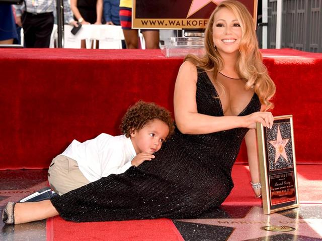 Mariah Carey's son Moroccan Cannon clings to his famous mom as she is honoured with a star on The Hollywood Walk of Fame. (AFP)