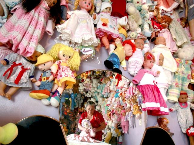 Rojas is reflected in a mirror as she changes the clothing of a doll at her home. She collected these dolls over a period of 20 years. (Reuters Photo/ Juan Carlos Ulate)