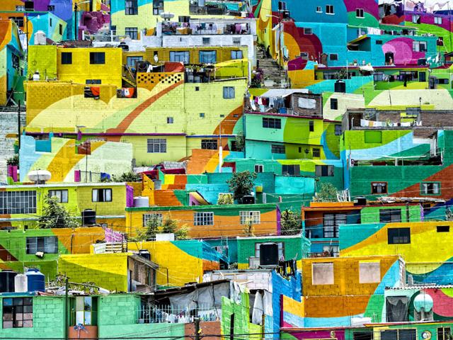 Residents had to be convinced to let artists paint their house walls before the project began. 'Las Palmitas' was first painted white after which artists created the mural. (AFP Photo)