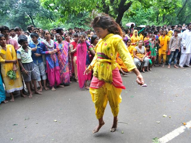 A Girl dancing during the religious procession dedicated to the Hindu goddess Shitla Mata at sukhna lake in Chandigarh. (Photo by Ravi Kumar/Hindustan Times)