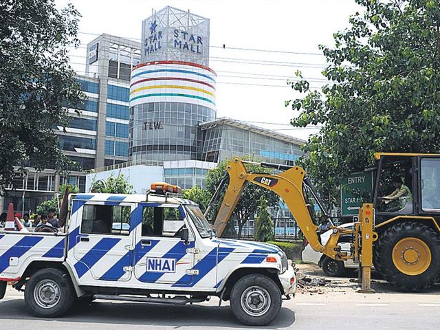 The NHAI on Tuesday afternoon blocked entry to Star Mall and DLF SEZ by digging up the approach road. The authority said that the builders had gained illegal access to the e-way (Parveen Kumar/ HT photo)
