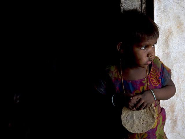 A girl holds a chapati in her hand, served as a part of mid-day meal programme, at Madkheda, Madhya Pradesh. (AP Photo)