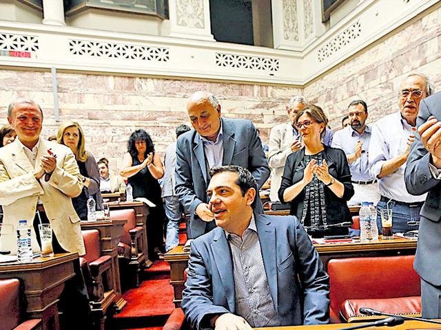 Greek PM Alexis Tsipras is applauded by lawmakers before addressing his parliamentary group meeting at the Greek Parliament in Athens on Friday. (Reuters Photo)