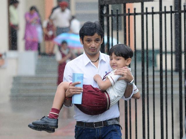 Parents picking their children back from the school during heavy rain in SAS Nagar on Saturday. Gurminder Singh/HT