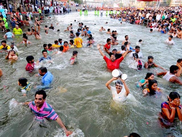 Devotees take a holy dip in River Godavari during the Simhastha Kumbh Mela at Ramkund in Nashik. (PTI Photo) 