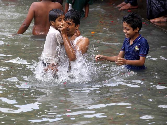 A young devotee along with his father takes a dip in the holy waters of River Godavari at the Nashik Kumbh Mela. (Arijit Sen/HT photo) 