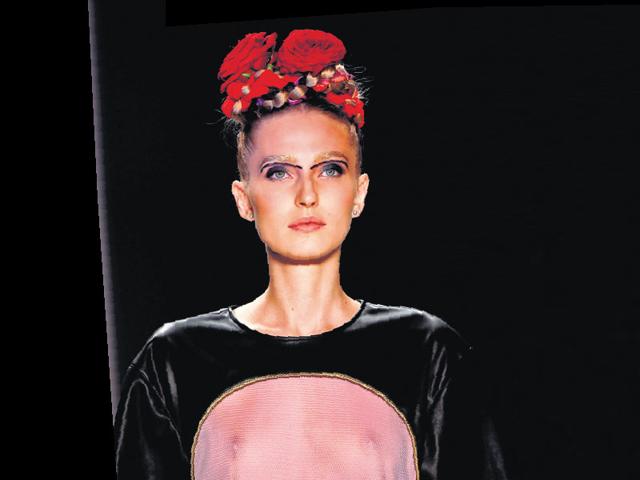 Floral accents on milkmaid braids seen at a show by Rebekka Ruétz at the Berlin Fashion Week. 