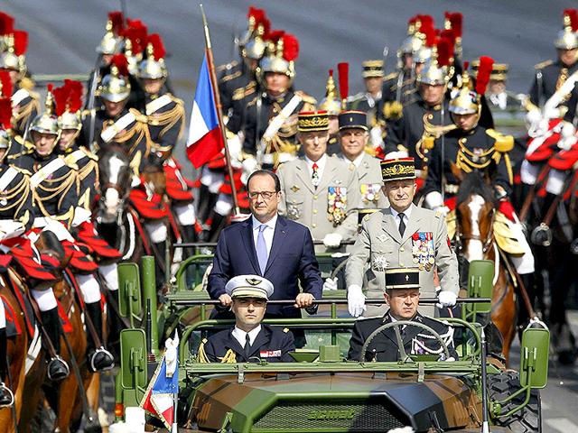 In a traditional beginning to the celebrations, French President Francois Hollande stands at attention in the command car as he reviews the troops while descending from the Champs Elysees. (Reuters/Mal Langsdon) In a traditional beginning to the celebrations, French President Francois Hollande stands at attention in the command car as he reviews the troops while descending from the Champs Elysees. (Reuters/Mal Langsdon)