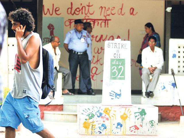 Students mill around an easel installation that displays how long the strike has been on. In the background, a poster says, "We do't need a karyakarta chairman". (Ht Photos)