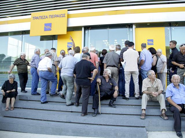 People wait to enter a Piraeus Bank branch at the city of Iraklio in the island of Crete, Greece. (Reuters Photo)