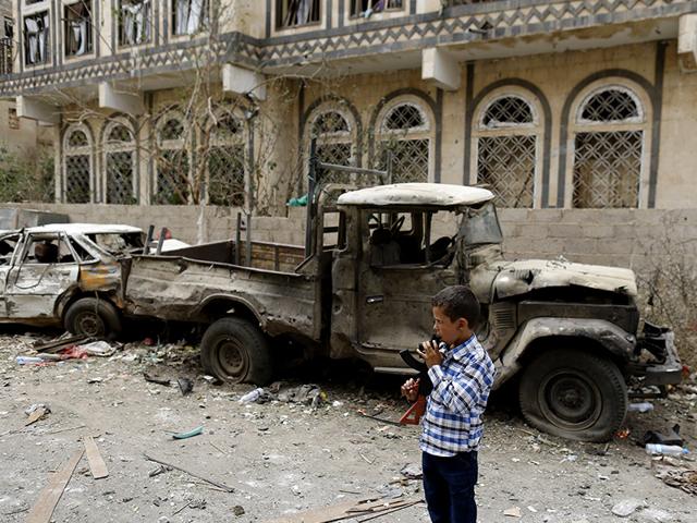 A boy holding a toy rifle stands at the site of a car bomb attack in Sanaa July 21, 2015. A UN aid ship arrived in Aden after four months carrying some much needed relief supplies. (Reuters Photo)