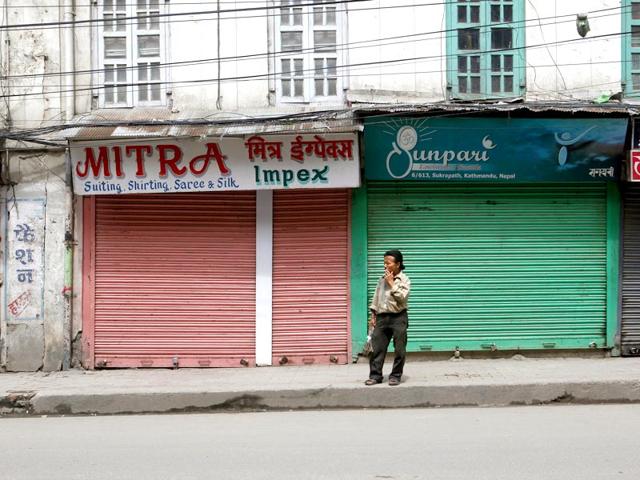 A Nepalese porter stands in front of closed stores during a general strike called by a splinter faction of the Unified Communist Party of Nepal Maoist, in Kathmandu, Nepal. A nationwide general strike enforced by the splinter faction against the drafting of a new constitution has crippled normal life across Nepal. (AP Photo)