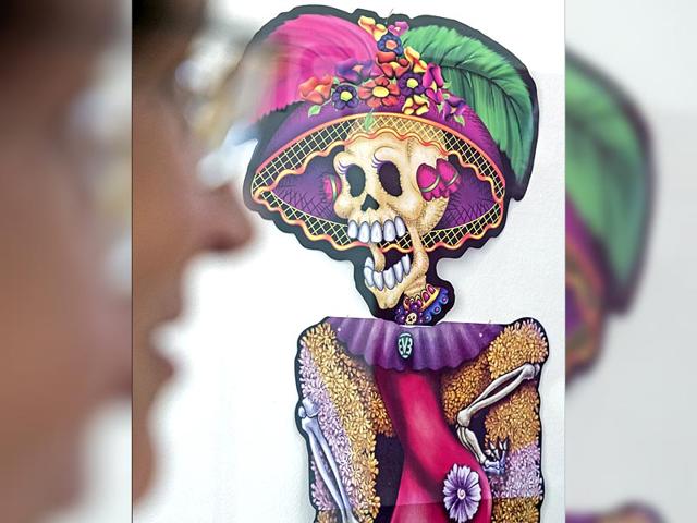 A woman stands in front of a Mexican skull motiff during the press preview at the exhibition. (AP Photo/Jens Meyer) A woman stands in front of a Mexican skull motiff during the press preview at the exhibition. (AP Photo/Jens Meyer)