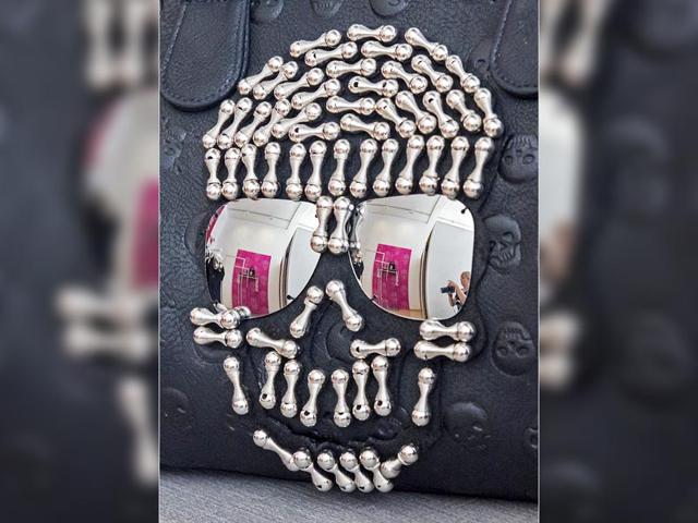 A woman with a camera is reflected in a handbag with skull motiffs during the press preview at the exhibition Sepuchral Store- Buy now, die later! (AP Photo/Jens Meyer) A woman with a camera is reflected in a handbag with skull motiffs during the press preview at the exhibition Sepuchral Store- Buy now, die later! (AP Photo/Jens Meyer)