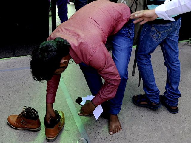 A candidate appearing for the AIPMT Exam removes his shoes and his kada (bracelet) before entering the premises for the All India Pre- medical test at Kendriya Vidyalay AGCR Colony in East Delhi. (Sonu Mehta/HT Photo)