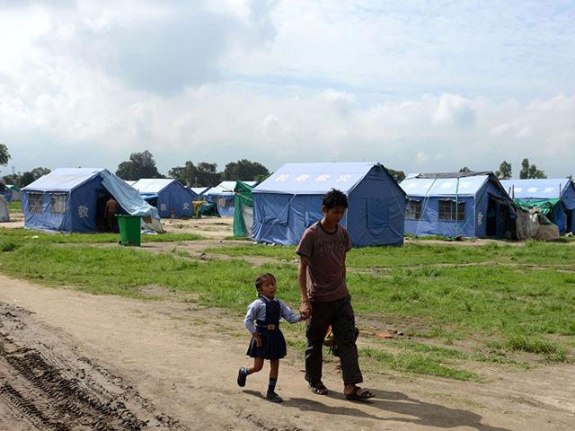 A young Nepalese schoolgirl walks with a family member at a relief camp for survivors of the Nepal earthquakes in Kathmandu. (AFP Photo) A young Nepalese schoolgirl walks with a family member at a relief camp for survivors of the Nepal earthquakes in Kathmandu. (AFP Photo)