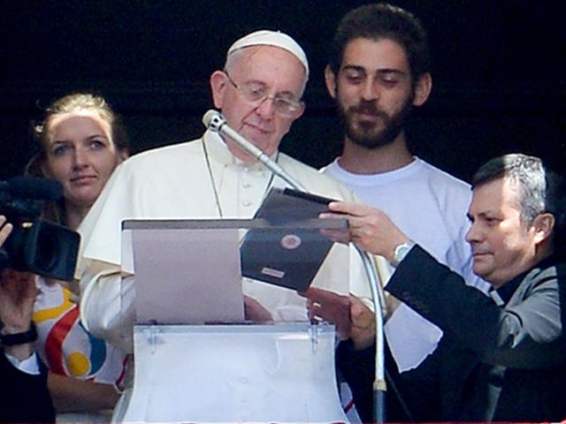 Pope Francis, accompanied by two Polish youths, uses an iPad to register online for the next 2016 World Youth Day in Poland during the Angelus prayer at the Vatican. (AFP Photo) Pope Francis, accompanied by two Polish youths, uses an iPad to register online for the next 2016 World Youth Day in Poland during the Angelus prayer at the Vatican. (AFP Photo)