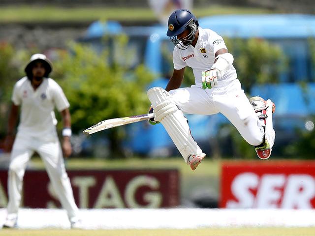 Chandimal jumps over the ball as he avoids being run out. (Reuters Photo)