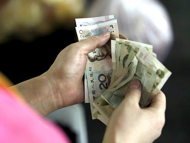 A customer counts Chinese Yuan notes at a market in Beijing, August 12, 2015. China shocked global markets on Tuesday by devaluing its currency after a run of poor economic data, a move it billed as a free-market reform but which some experts suspect could be the beginning of a longer-term slide in the exchange rate. (REUTERS) A customer counts Chinese Yuan notes at a market in Beijing, August 12, 2015. China shocked global markets on Tuesday by devaluing its currency after a run of poor economic data, a move it billed as a free-market reform but which some experts suspect could be the beginning of a longer-term slide in the exchange rate. (REUTERS)
