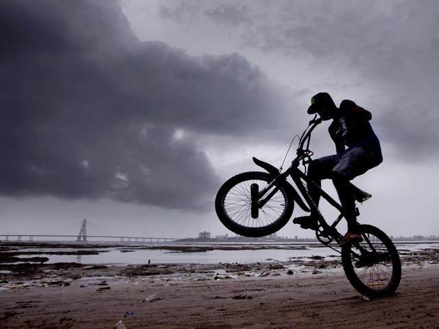 A young boy performs a stunt on his bicycle at Dadar Chowpatty, in Mumbai. (Kunal Patil/HT photo)