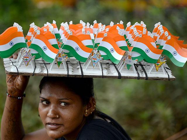A woman selling miniature Indian tricolour flags waits for customers at the corner of a busy crossroad in Mumbai. (AFP Photo)