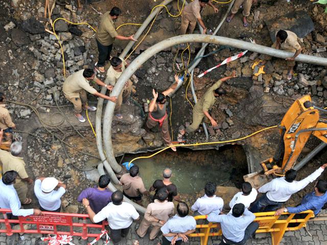 BMC workers repair a water pipeline after it burst at Dadar, in Mumbai. (Photo credit: Bhushan Koyande)