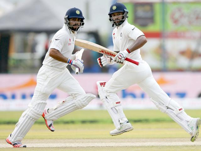 India's captain Virat Kohli (L) and his teammate Shikhar Dhawan runs between wickets during the second day of their first test cricket match against Sri Lanka in Galle,. REUTERS/Dinuka Liyanawatte
