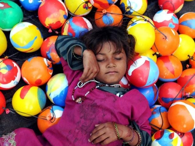 A girl takes a nap outside the historic Kali Mata temple during Navratre festival in Patiala. (Bharat Bhushan/HT)