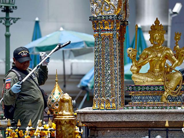 An EOD policeman inspects the Erawan shrine which is located in the heart of Bangkok's tourist and commercial centre. (AFP Photo)