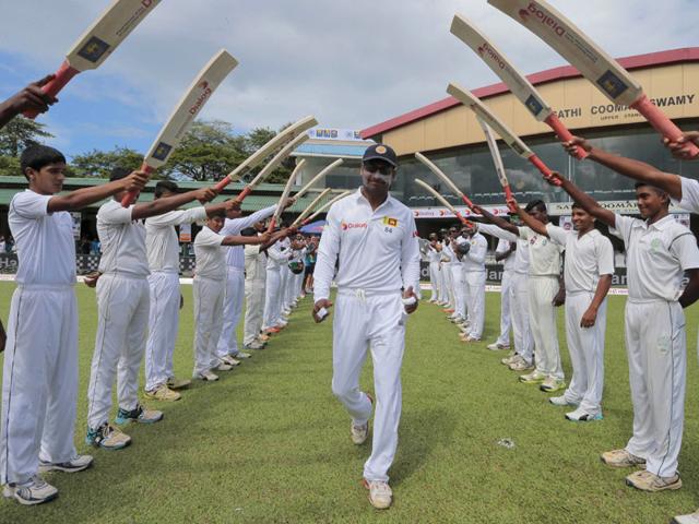 Sri Lanka's Kumar Sangakkara, centre, is greeted with an arch of cricket bats as he enters the field for the last match of his Test career, Day 1 of the second Test against India in Colombo, Sri Lanka, on August 20, 2015. (AP Photo)