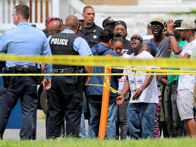 People confront police at the scene of a shooting at Walton Avenue and Page Boulevard, where a black teenager was shot dead by cops, on Wednesday. (St Louis Post via AP Photo) People confront police at the scene of a shooting at Walton Avenue and Page Boulevard, where a black teenager was shot dead by cops, on Wednesday. (St Louis Post via AP Photo)