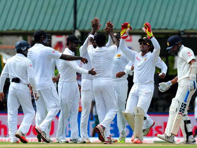 Sri Lankan bowler Dhammika Prasad (C) celebrates with teammates after the dismissal of Indian opener Murali Vijay (R) on Day 1 of the second Test match against India at the P Sara Oval Stadium in Colombo. (AFP Photo)